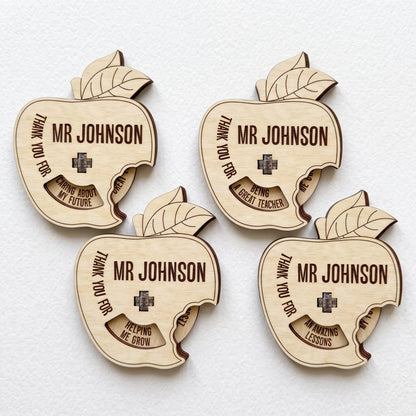 Four laser cut plywood apple teacher gifts with spinning wheel showing thank you messages laid on plain white background.