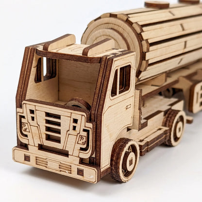 A wooden laser-cut toy tanker truck made from natural plywood, shown on a clean white background.