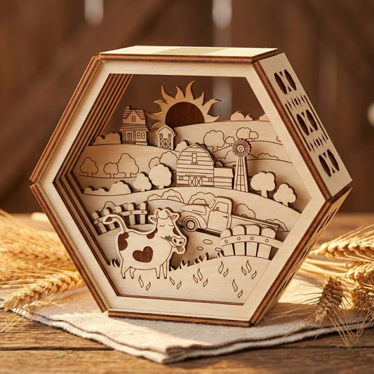 Front view of a multi-layered laser cut plywood shadow box. The 3D wooden art depicts a rural farm with a vintage truck, fences, and rolling hills. Intricate geometric cutouts on the side panels of the hexagonal frame show the natural wood texture.