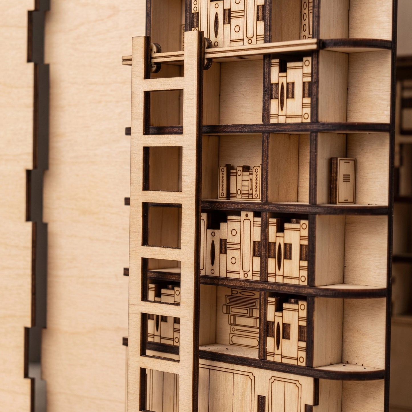 Close-up of a laser-cut birch plywood library book nook shelf featuring a tiny wooden ladder, engraved miniature books, and dark burnt edges.