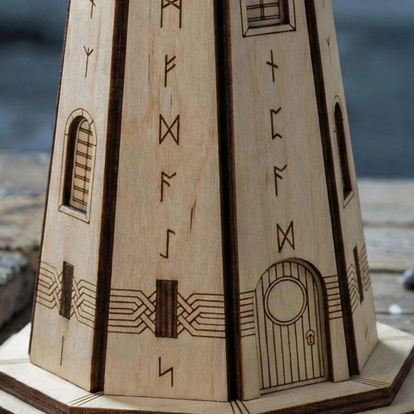 Macro texture shot showing detailed Elder Futhark runes engraved on a natural wood laser cut plywood lighthouse.