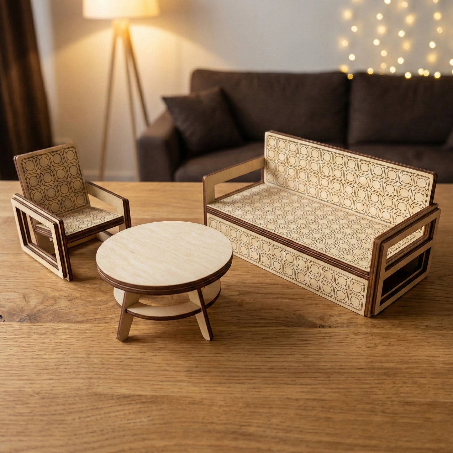 Miniature wooden living room set crafted from laser cut plywood. The sofa and chair feature an intricate square-and-circle engraved texture. Shown on a wooden table with soft warm lighting and fairy lights in the background.