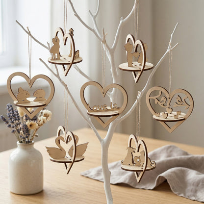 A collection of seven 3D laser-cut plywood heart ornaments hanging from a white decorative tree. Each heart features a unique miniature scene, including swans, lovebirds, couples, hedgehogs, and dogs. Handcrafted natural wood decor for weddings, Valentine's Day, or home styling.