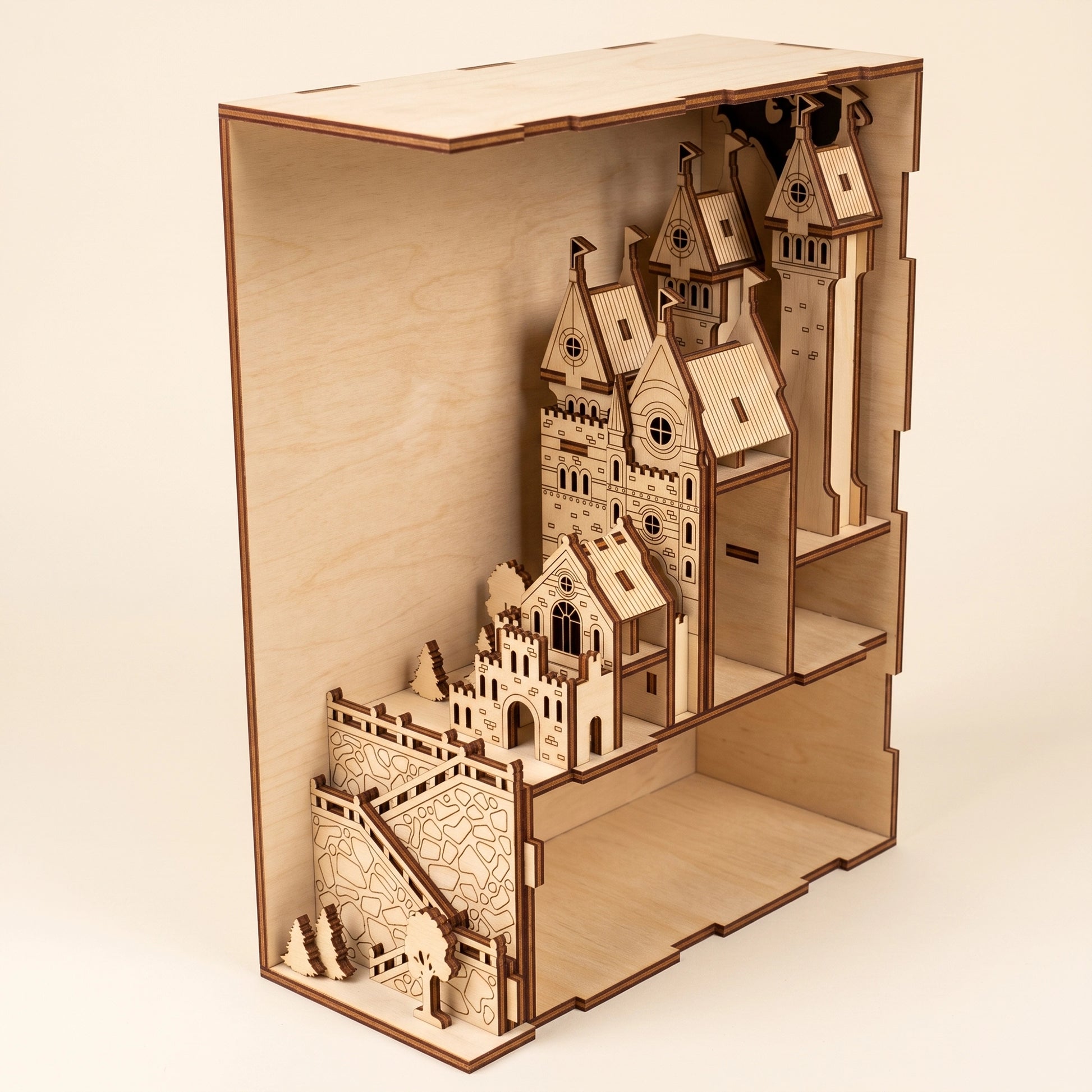 An unlit, detailed laser cut plywood medieval castle book nook model viewed from a side angle.