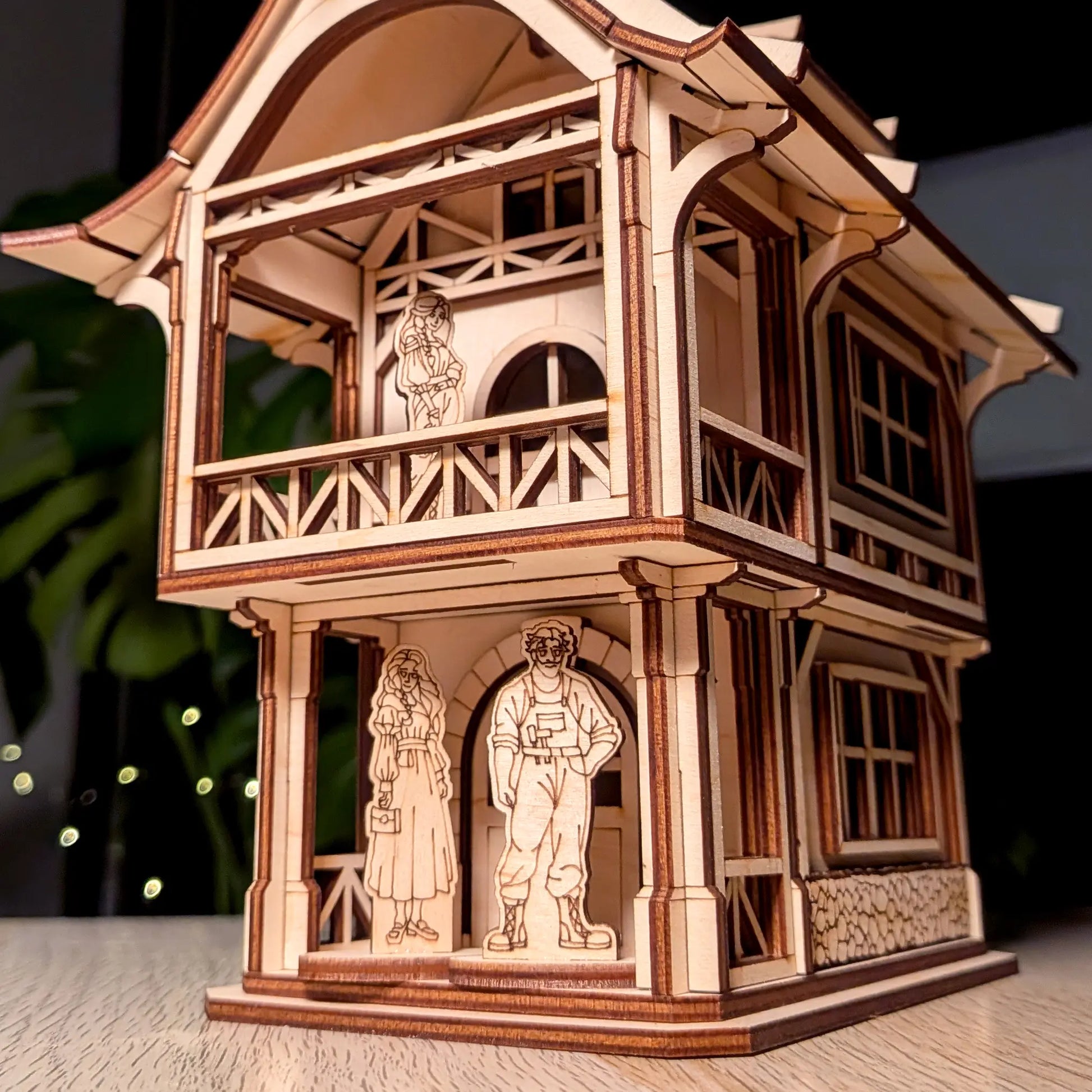 Low angle close-up of a medieval laser cut plywood townhouse showing three highly detailed wooden resident family figures.