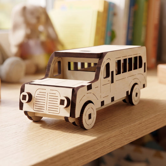 Laser cut plywood mini bus model, displayed on a wooden surface with books nearby