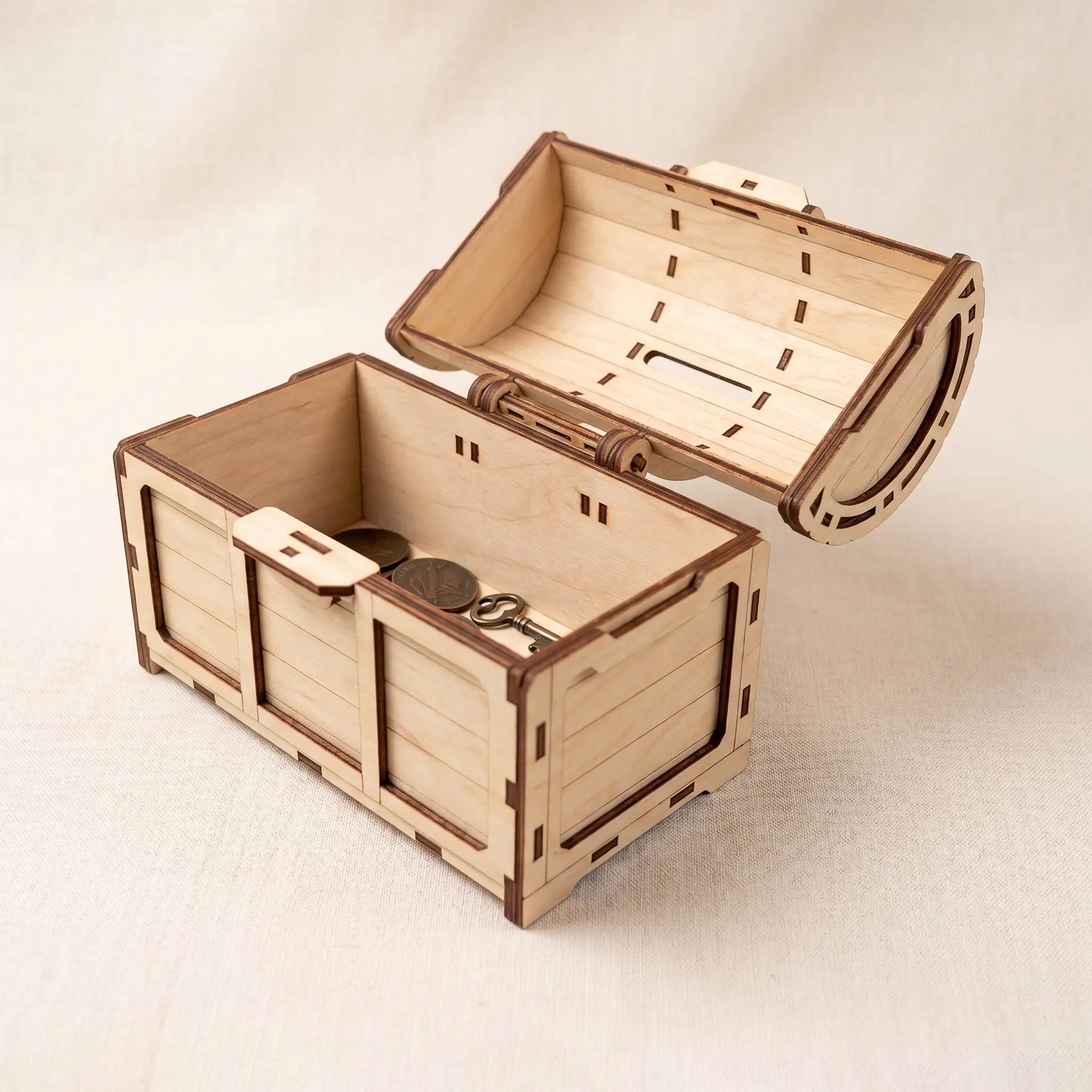 Wooden treasure chest laser cut model with a key on a light background