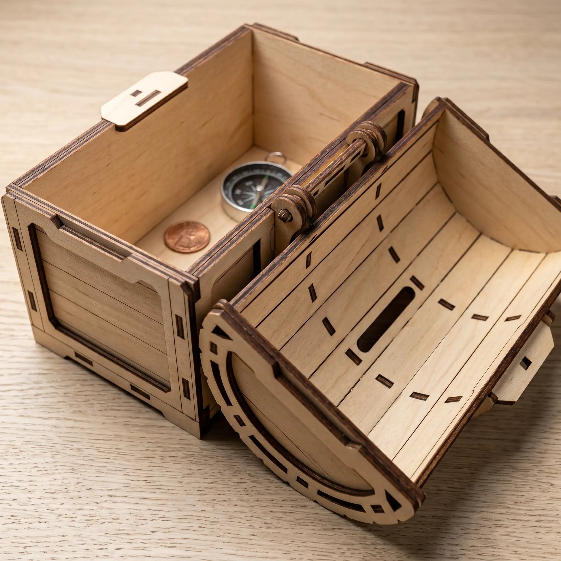 Wooden treasure chest model with a compass and coin on a wooden surface