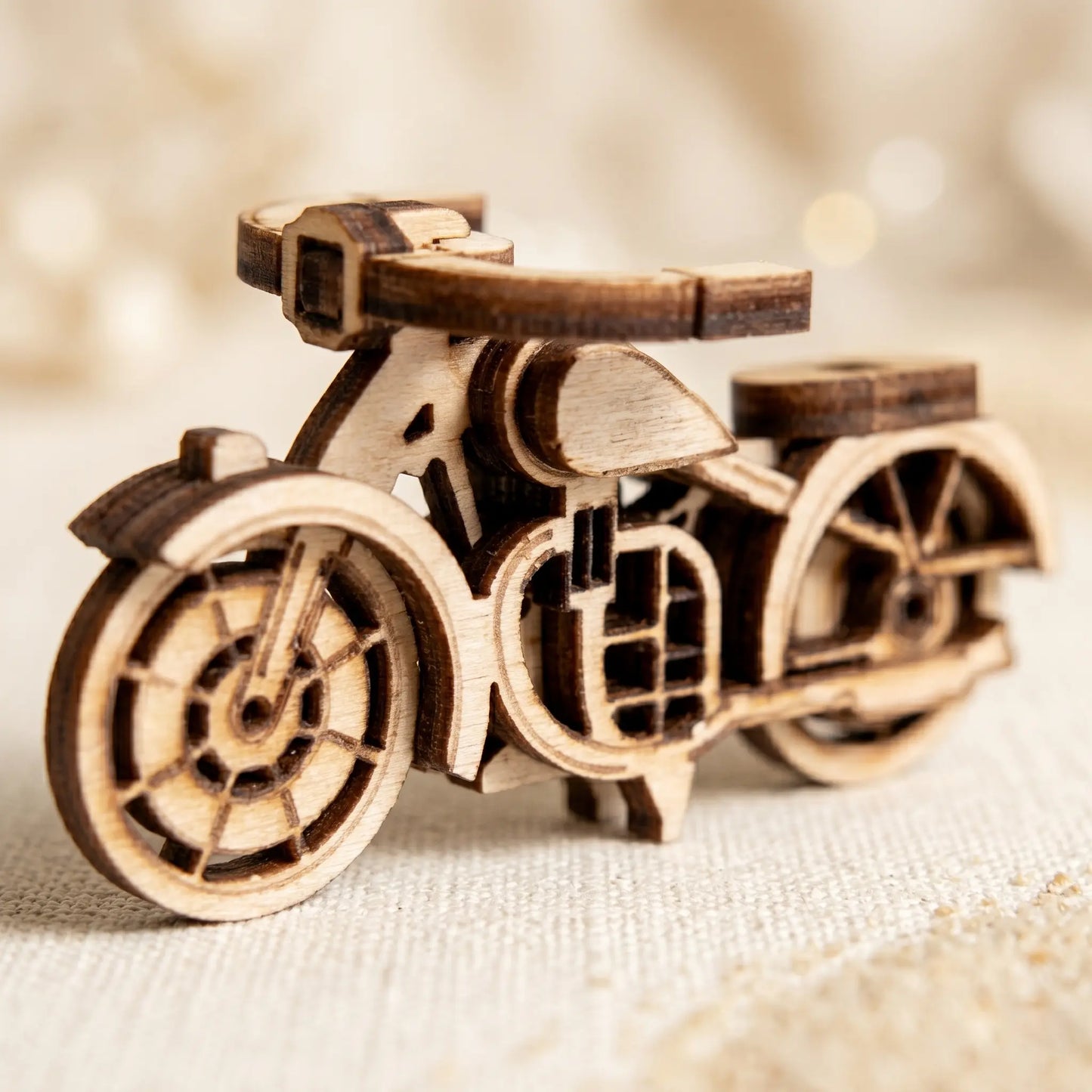 Wooden model of a motorcycle on a textured surface with a blurred background