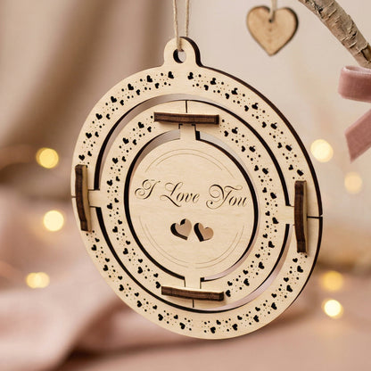 Angled shot of a handcrafted wooden Valentine's gift hanging on a birch-style branch with a pink velvet bow. The plywood ornament showcases precise laser-etched details and heart motifs. Styled in a warm, aesthetic environment with soft ambient lighting.