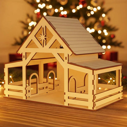 
Wooden laser cut Nativity barn #5 with extended covered porch, detailed beam structure, and prominent Bethlehem star cutout on the gable, illuminated warmly against a softly blurred Christmas tree background.