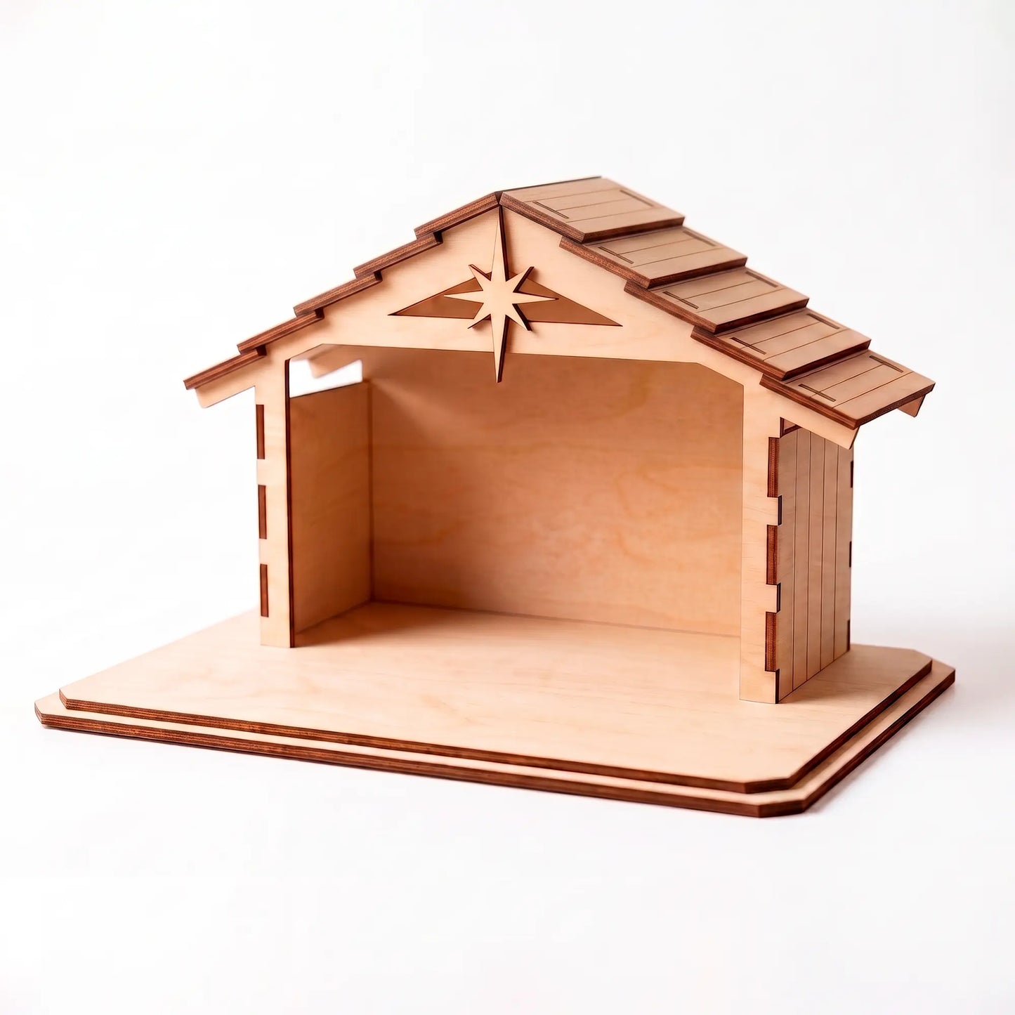 Empty laser cut plywood nativity stable featuring a star cutout on the shingled roof, shown against a plain white base.