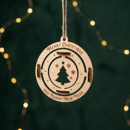 A hanging laser-cut plywood Christmas bauble ornament with an engraved pine tree against a dark green bokeh light background.