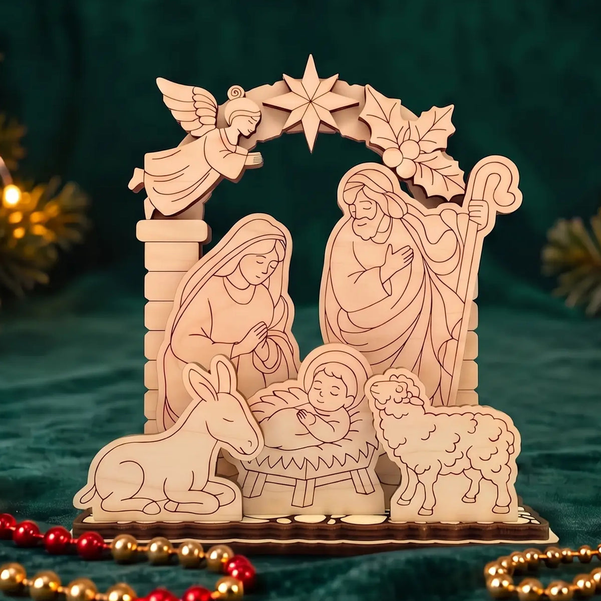 Laser cut plywood holy family nativity scene placed on rich green velvet with festive garland lights.