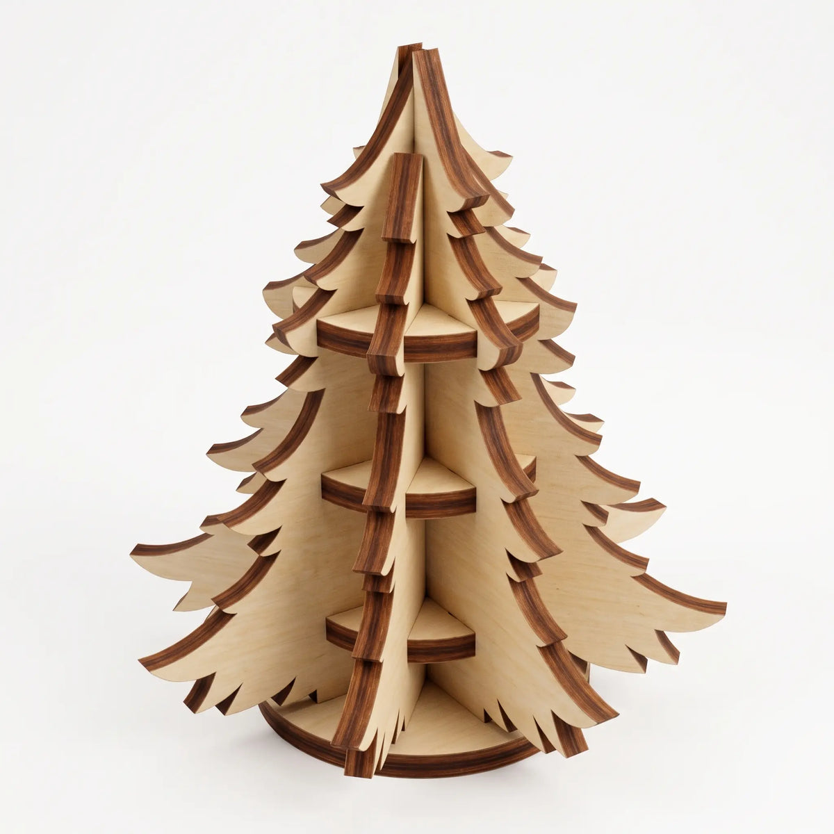 3D layered laser cut plywood miniature Christmas tree ornament with burnt laser edges standing on white background.