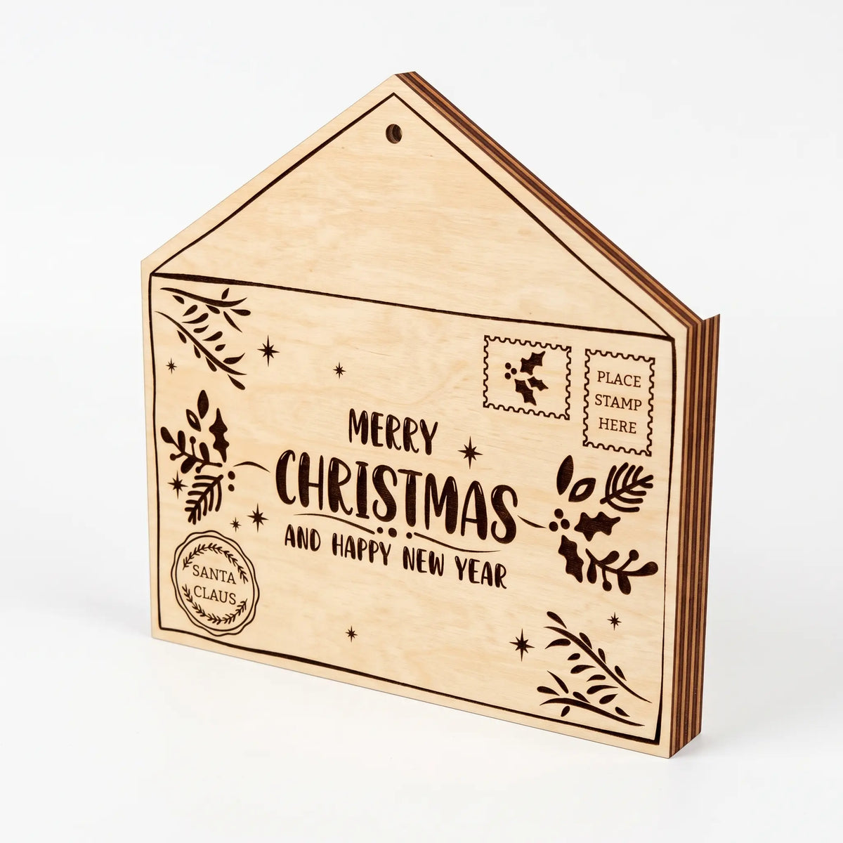 Side view of laser cut plywood Santa letter envelope box with Merry Christmas lettering on white surface.