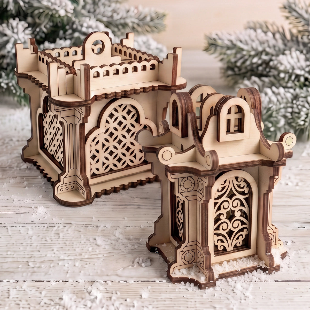 Two miniature laser cut plywood architectural lanterns with cutout lattice windows standing on snowy white wooden table.