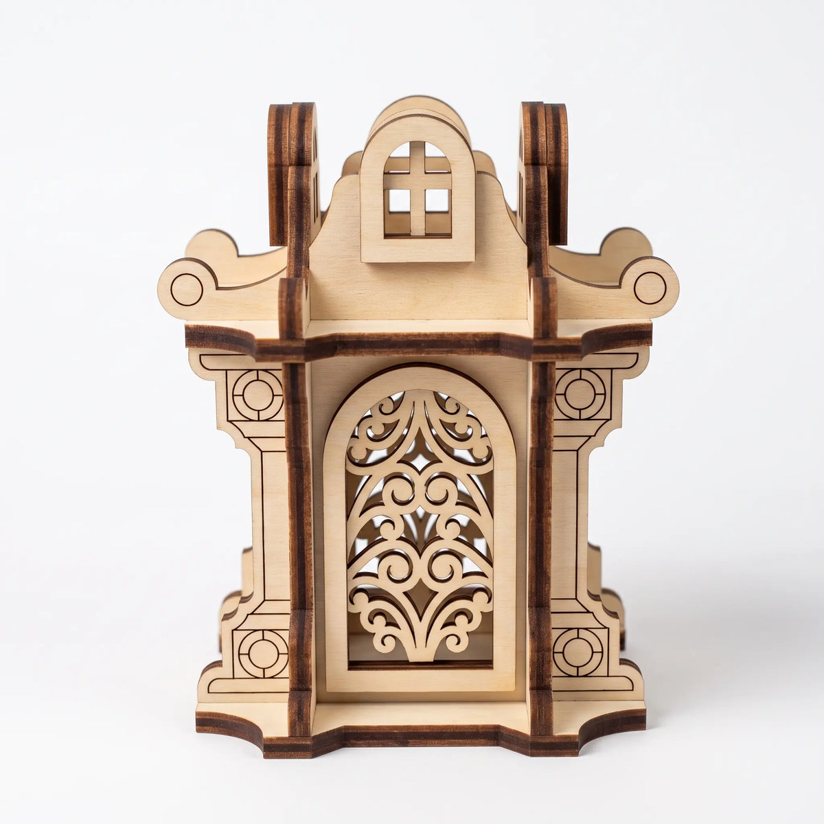 Front view of decorative laser cut plywood candle lantern featuring filigree carved arch windows on plain white background.