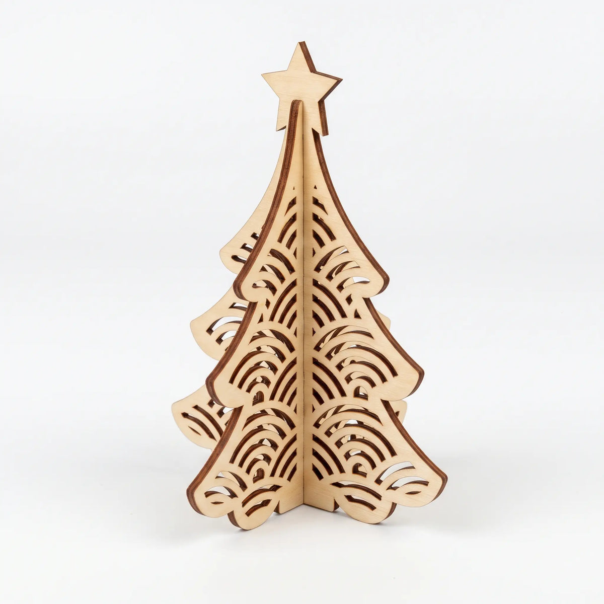 3D laser cut plywood Christmas tree figurine with scalloped concentric arch cutouts and star topper on white background.