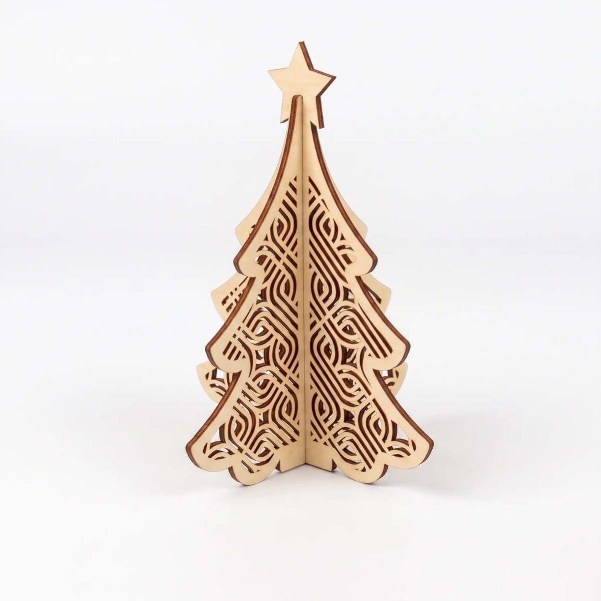 Intricate 3D laser cut plywood Christmas tree figurine with carved Celtic knot patterns and star topper on white backdrop.