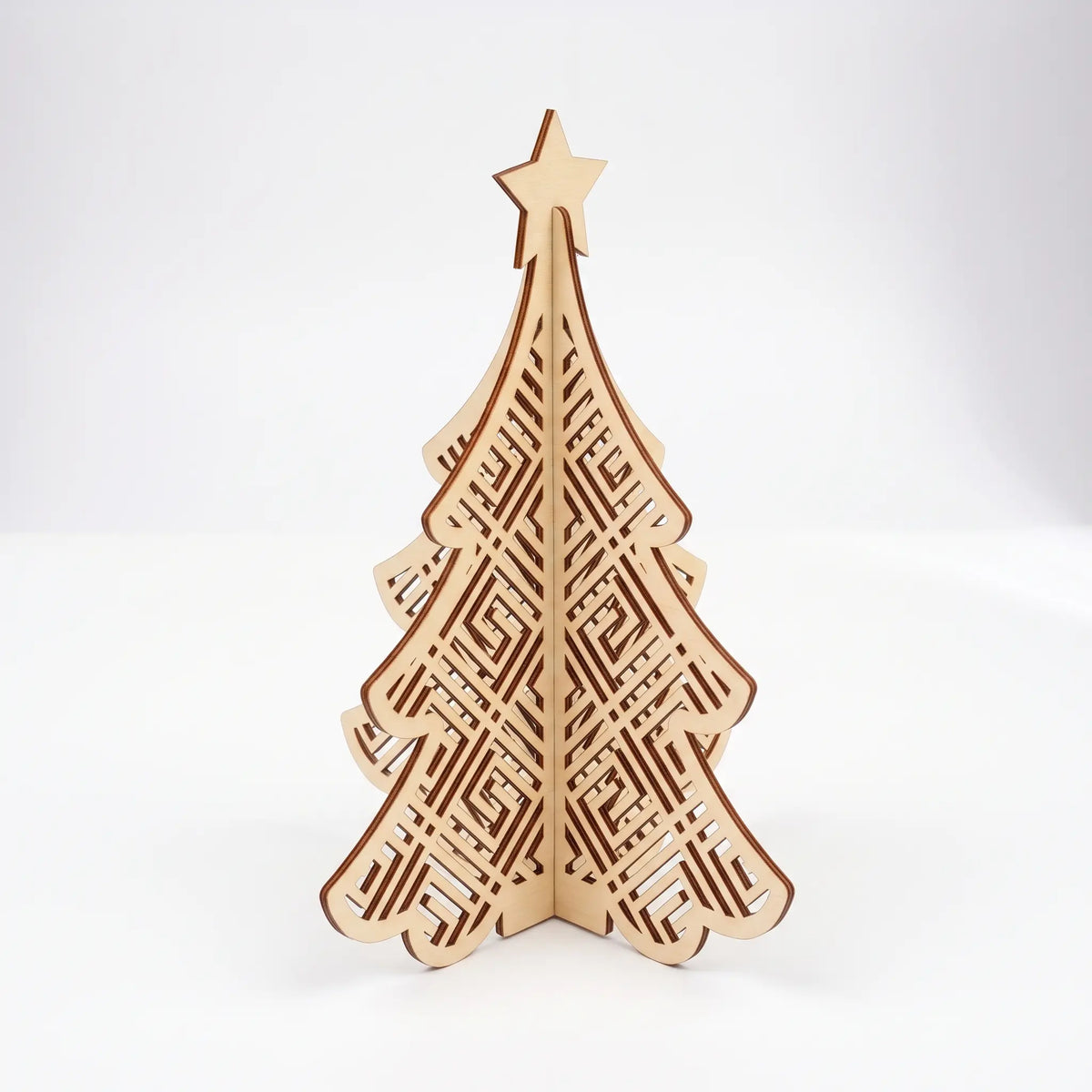 3D laser cut plywood Christmas tree figurine with Greek key maze pattern and star topper standing on plain white surface.