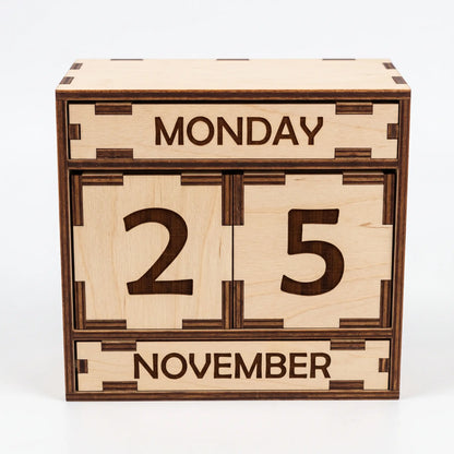 Front view of desktop laser cut plywood perpetual calendar box with date blocks and engraved slats on white background.