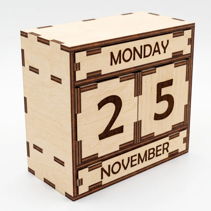 Angle perspective view of natural laser cut plywood perpetual calendar box with engraved slats on plain white backdrop.
