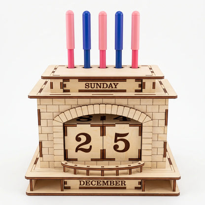 Front view of laser cut plywood fireplace perpetual calendar and pen holder stand holding five pens on white background.