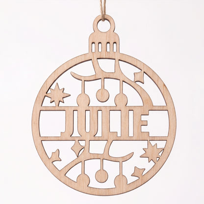 Front view of laser cut plywood Julie name bauble ornament featuring cut out garland and star motifs on white.