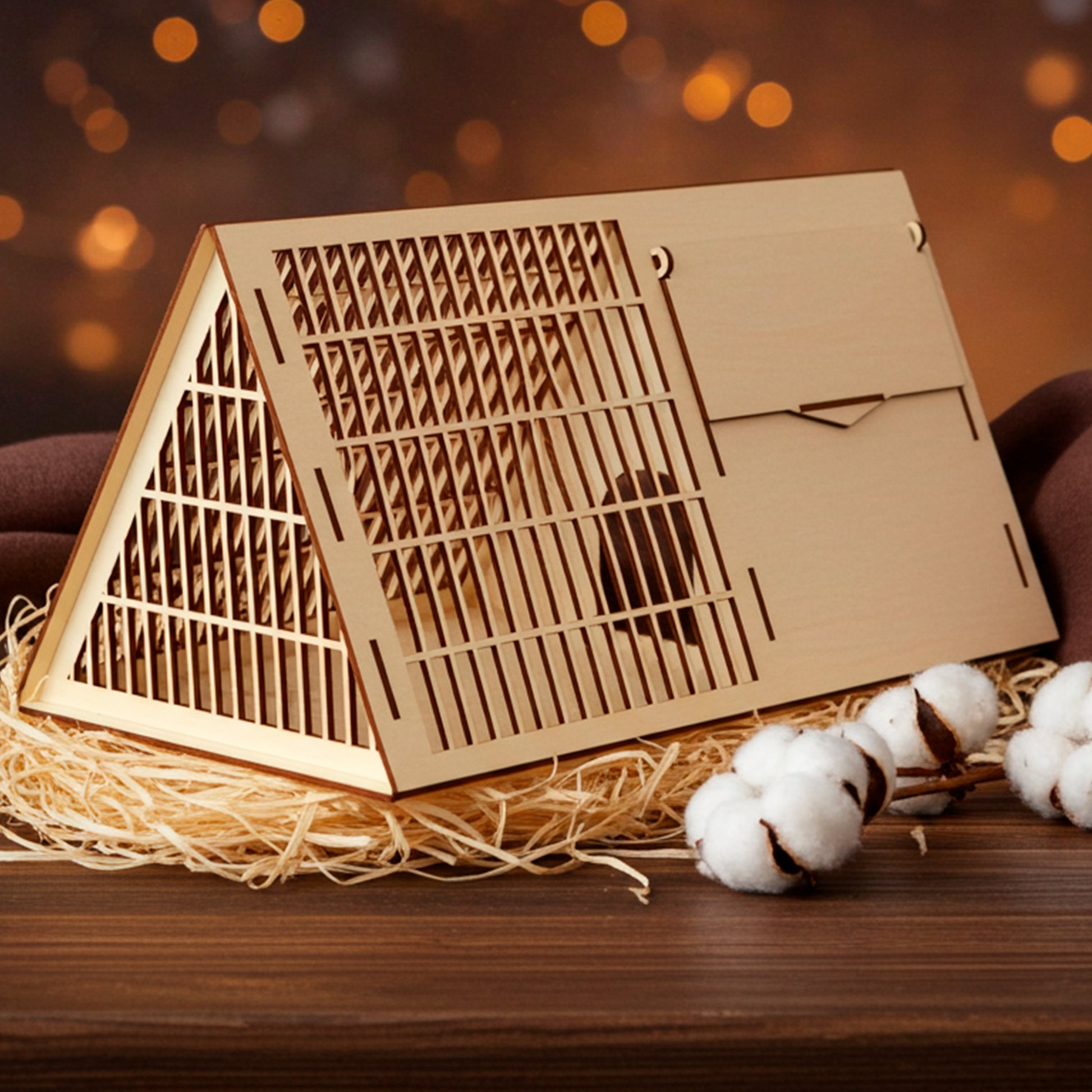 Laser cut wooden plywood Pet Cage or habitat divider, featuring an A-frame triangular roof and detailed slotted ventilation grid on the sides and top. The lightweight plywood structure, designed as a DIY kit, has a small, central access door on the side panel. White background, showing the wood craftsmanship.