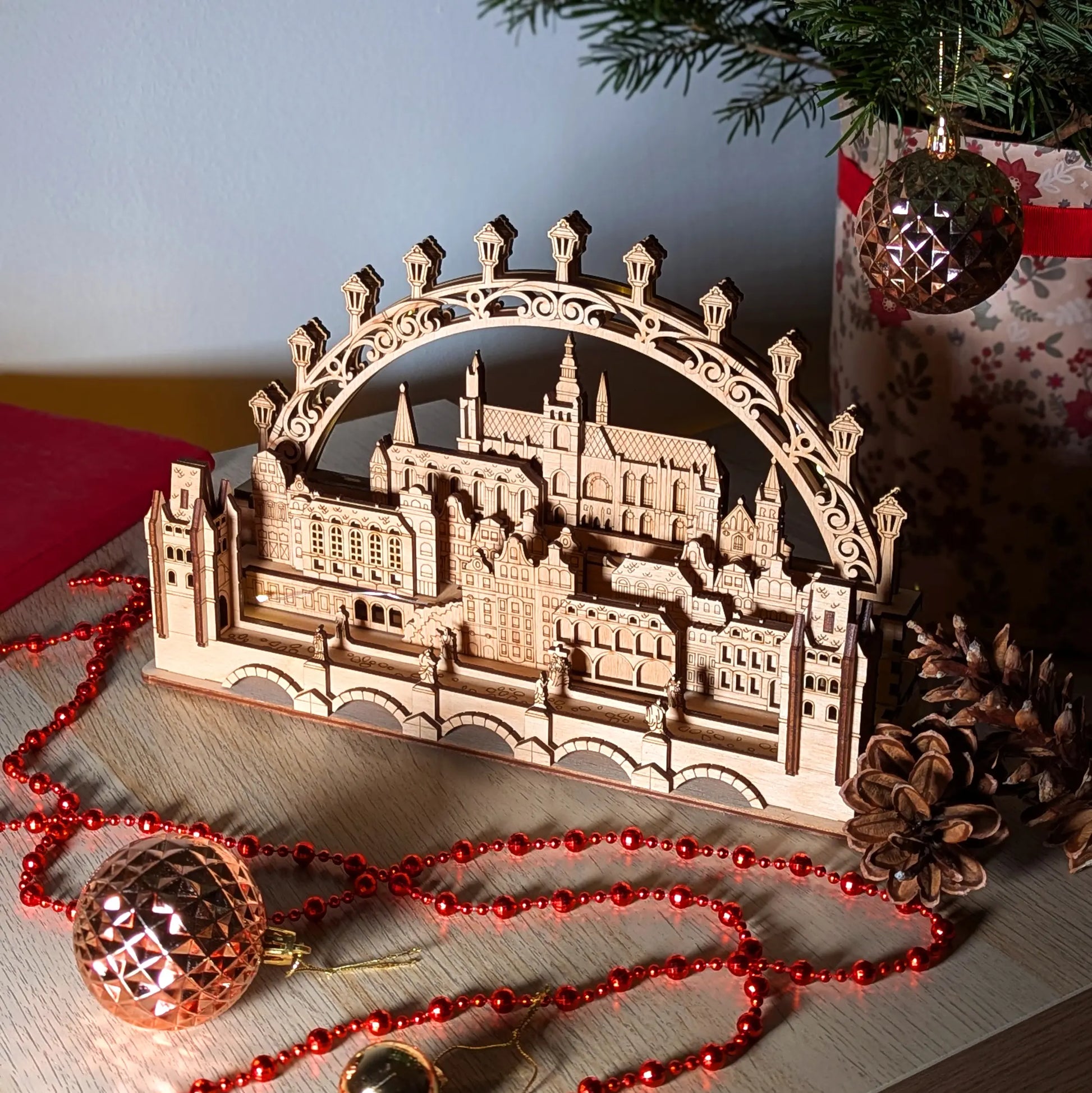 An elevated high-angle perspective view of a beautiful 3D Prague cityscape holiday arch display made from laser cut plywood.