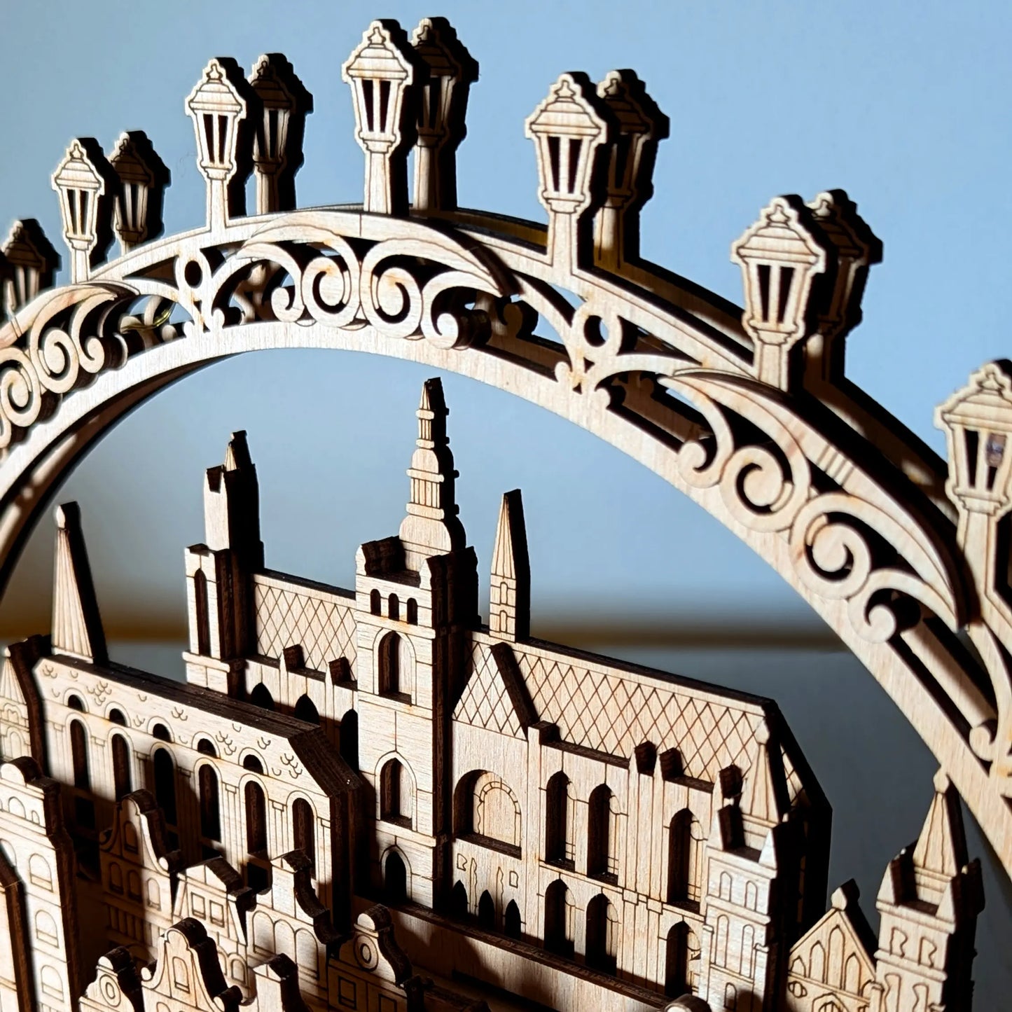 A macro close-up shot focusing on an intricate street lantern arch and gothic castle spires made from laser cut plywood.