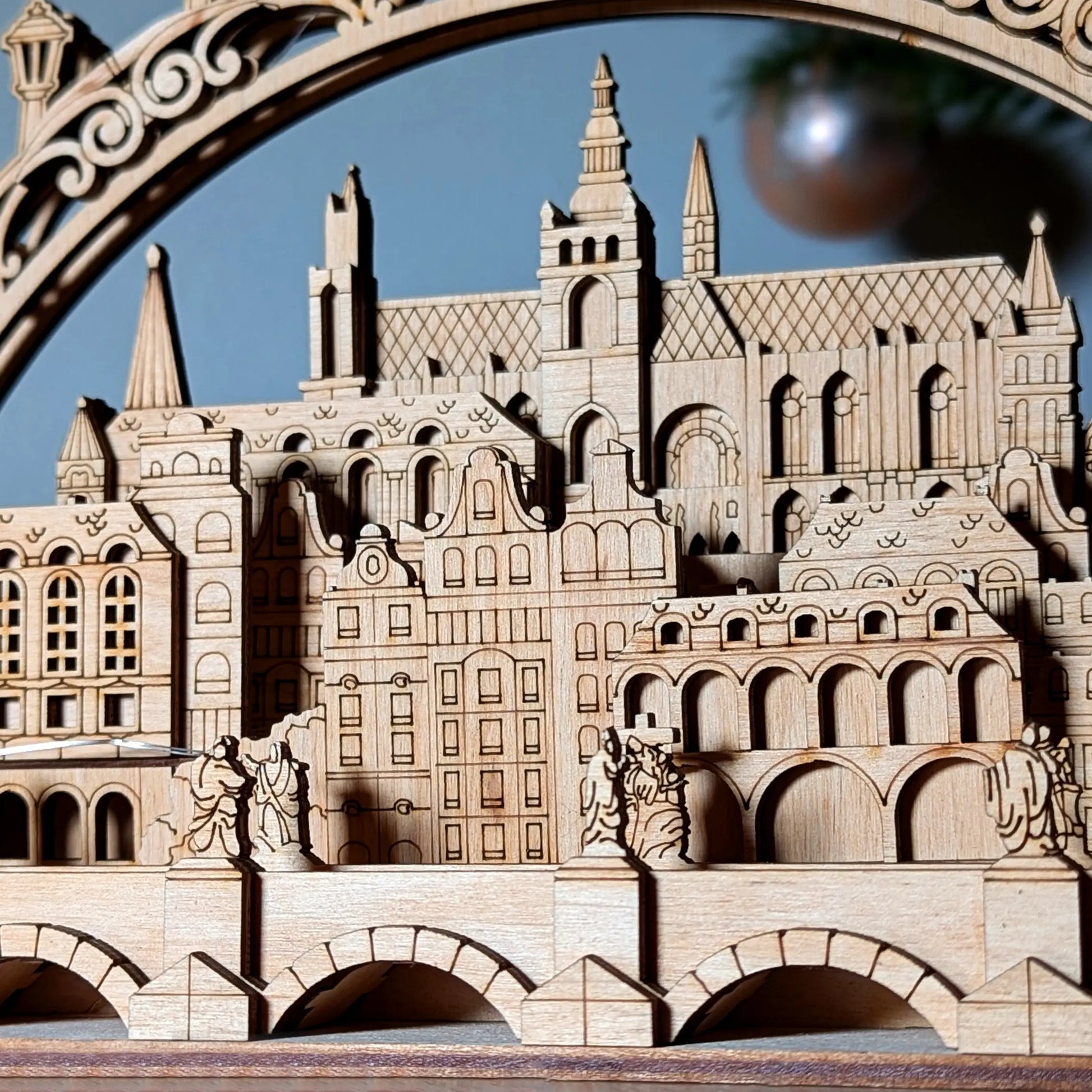 A stunning wide holiday lifestyle staging shot of a decorative 3D Prague old town silhouette arch made of laser cut plywood.