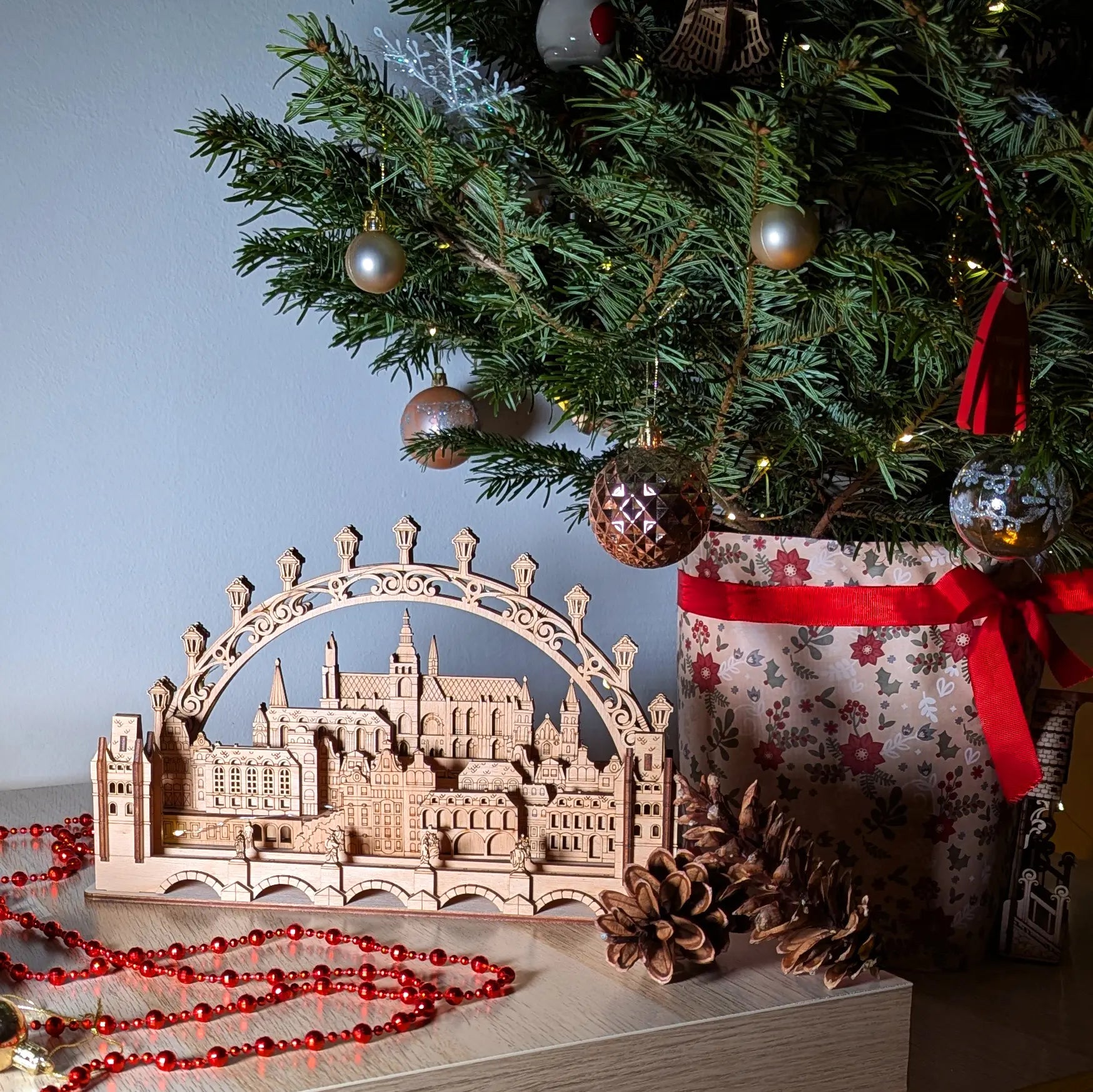 Cozy side perspective view of a miniature 3D Prague cityscape holiday centerpiece beautifully made of laser cut plywood.