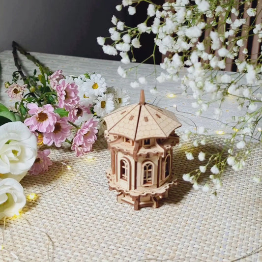 Laser cut plywood tower displayed with floral decor, showing off the precision of the wood assembly.