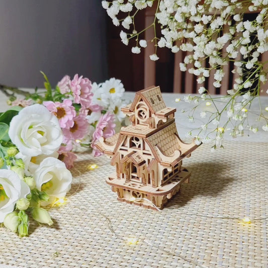 Charming laser cut plywood fairy house on a textured surface. Perfect miniature home with intricate wooden details.