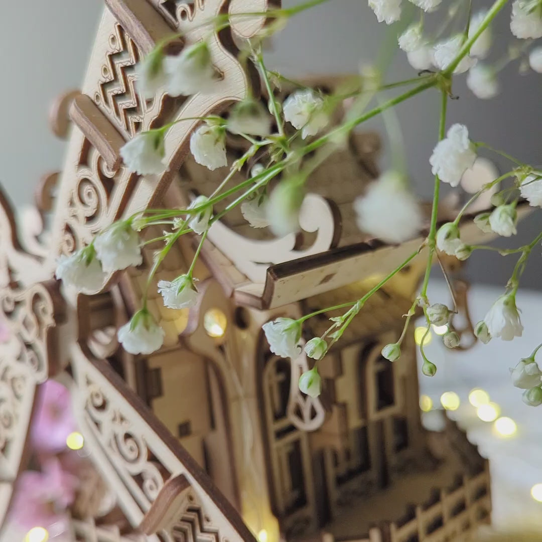 Stunning three-quarter view of a vintage 3D miniature windmill with warm glowing lights, made from layered laser cut plywood.