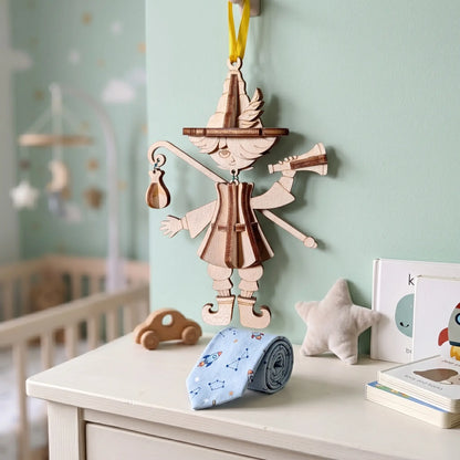Laser cut wooden marionette puppet hanging on a nursery wall, whimsical bard ornament SVG design