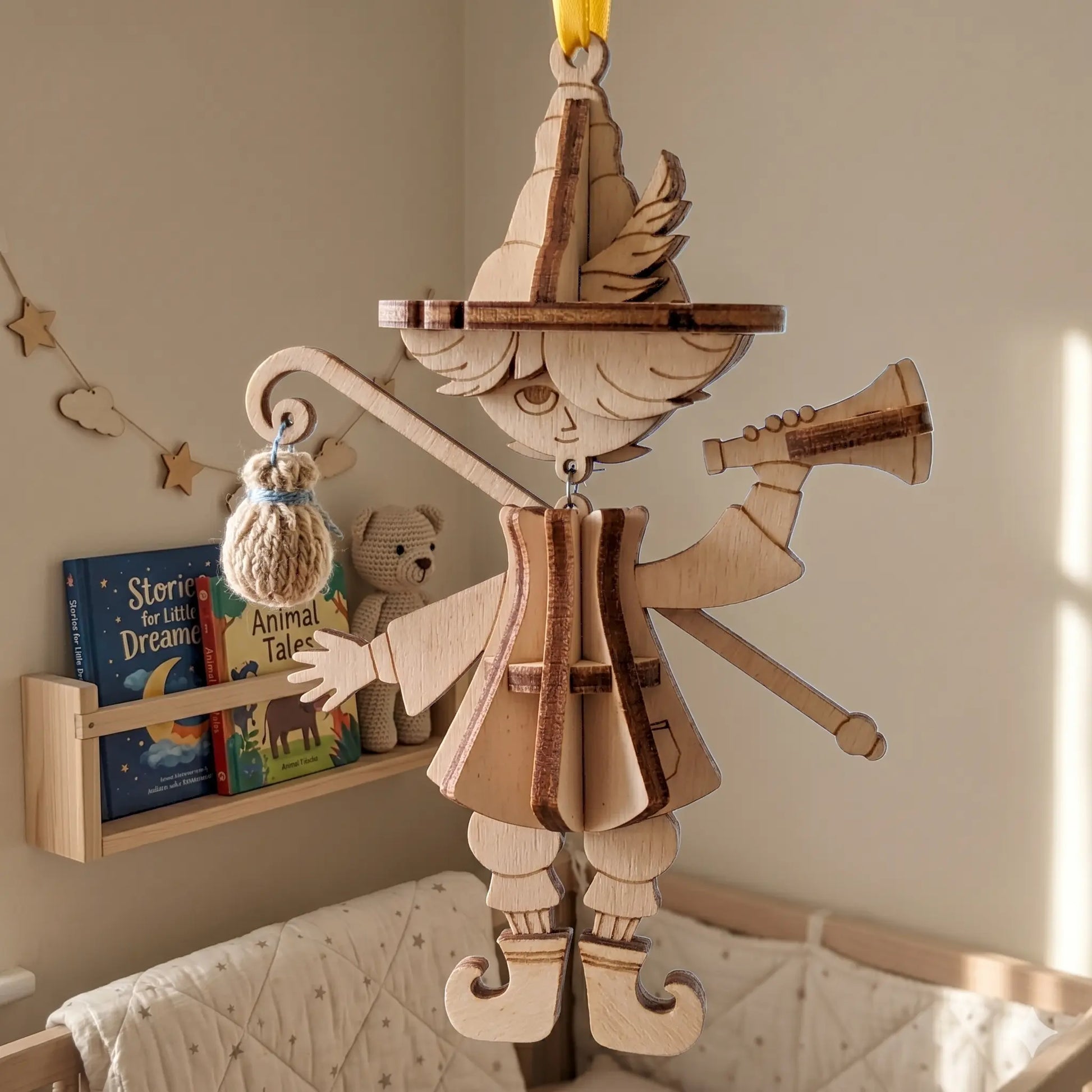Close up of a wooden laser cut bard marionette puppet ornament hanging in a cozy nursery