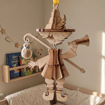 Close up of a wooden laser cut bard marionette puppet ornament hanging in a cozy nursery