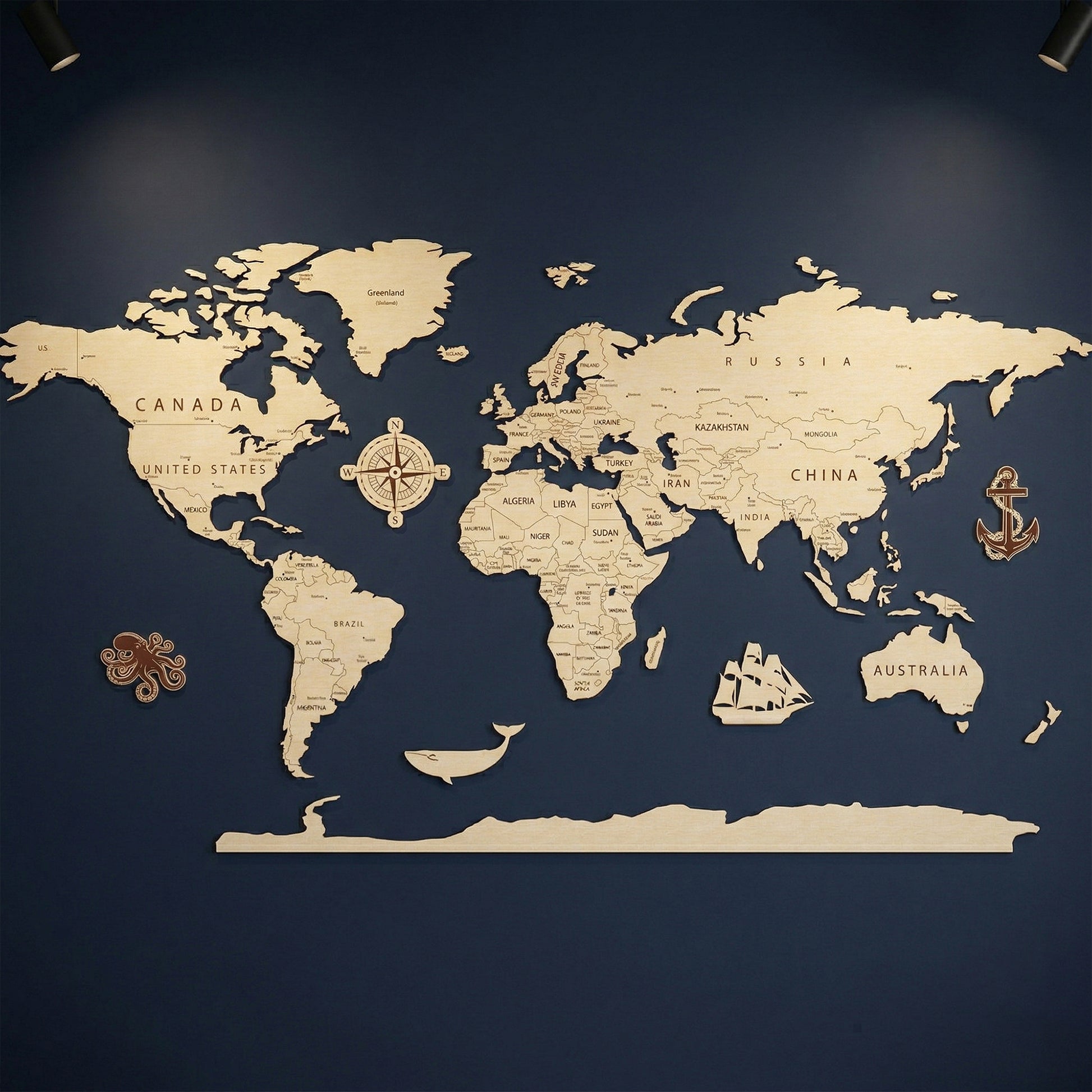 A full 3D world map made of laser-cut plywood mounted on a dark blue wall. The natural wood map features engraved country names and borders, accompanied by decorative wooden icons including a compass rose, anchor, octopus, whale, and sailing ship.