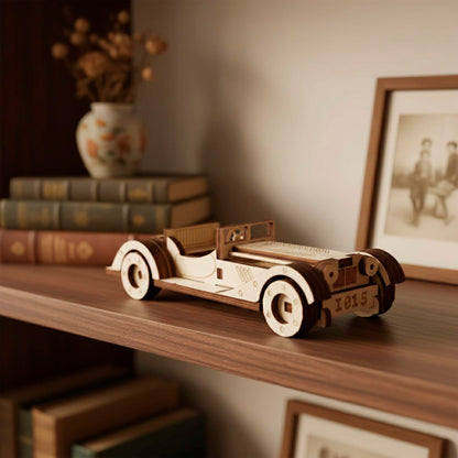 Three-quarter front view of a laser cut wooden plywood classic car model. Features engraved "1015" license plate, round headlights, and detailed grill. Resting on a dark wooden shelf with framed photos and books in the background.