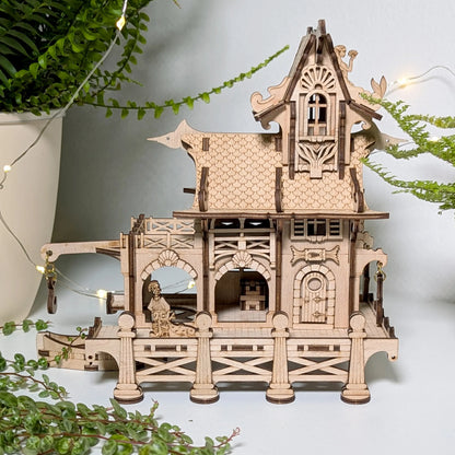 A stunning wide sea theme lifestyle staging photo of a miniature tabletop sailor house made from laser cut plywood.
