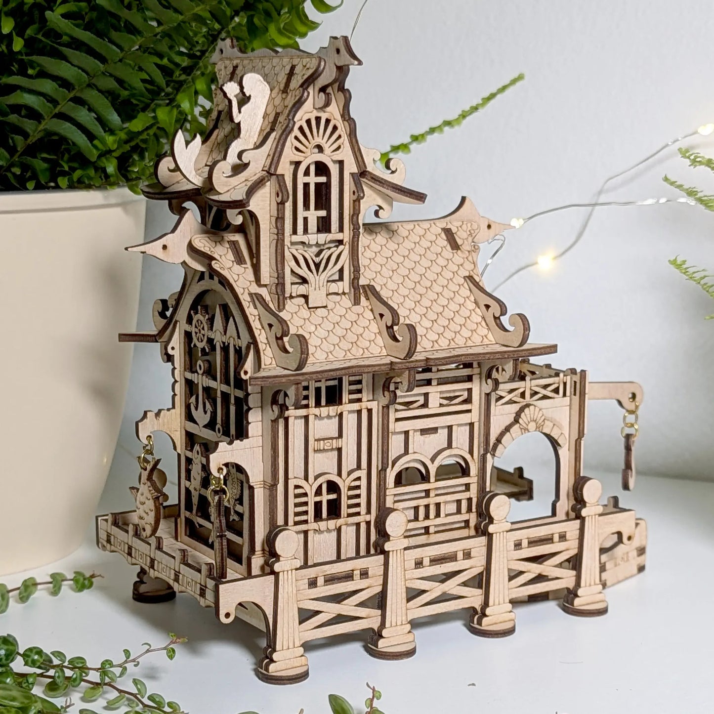 A lovely three-quarter view of a miniature wooden nautical lighthouse box crafted beautifully from laser cut plywood.