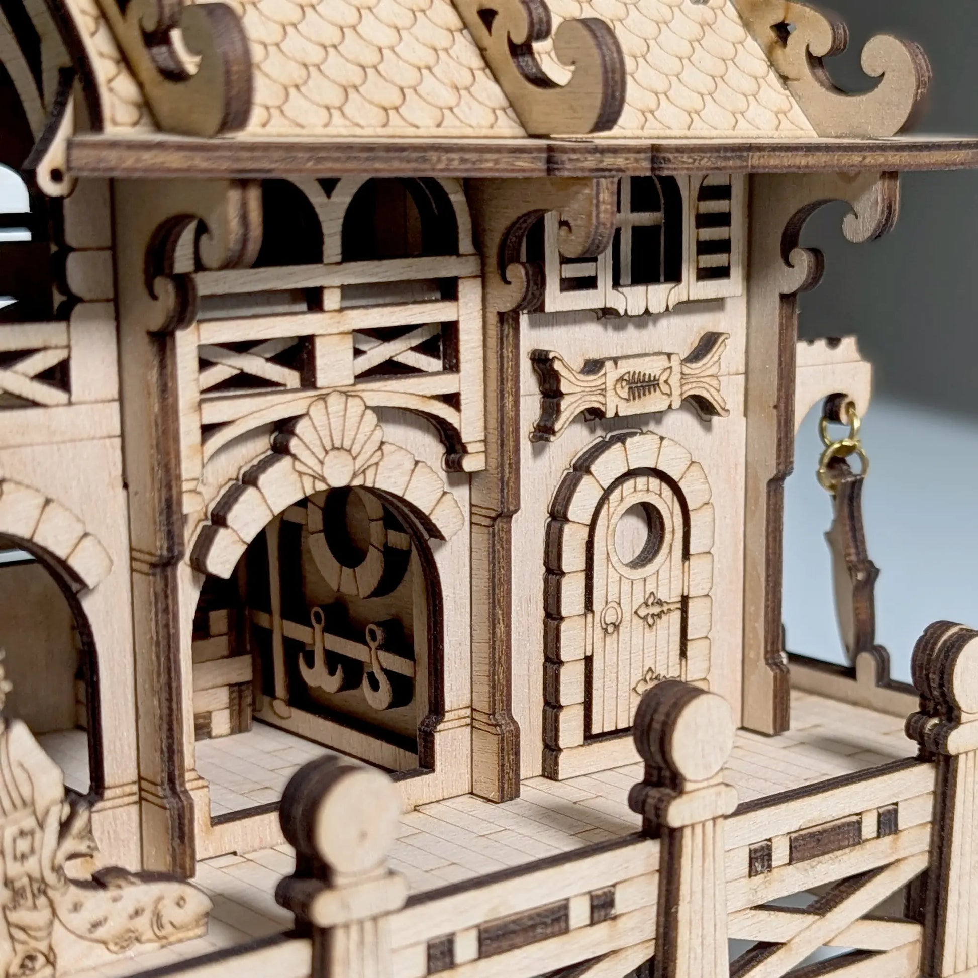 A straight side profile view highlighting the clean interlocking tabs of a mini marine house of laser cut plywood.