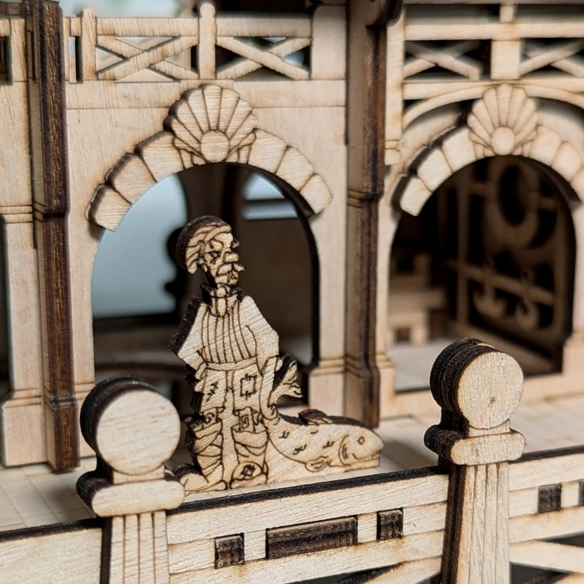 Tighter angled profile view showcasing the detailed nautical window frame structures of a laser cut plywood house.