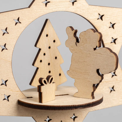 Close-up of slotted laser cut plywood Santa, tree, and gift box silhouettes inside a 3D wooden star ornament.