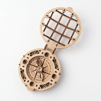 Top view of open laser cut plywood Santa compass with engraved compass rose and cardinal points on white backdrop