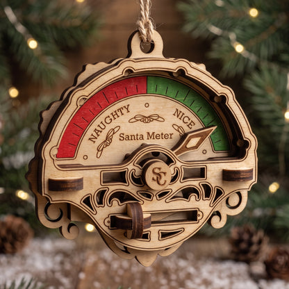 Laser cut plywood Santa meter hanging from jute twine on Christmas tree with pointer indicating nice position.