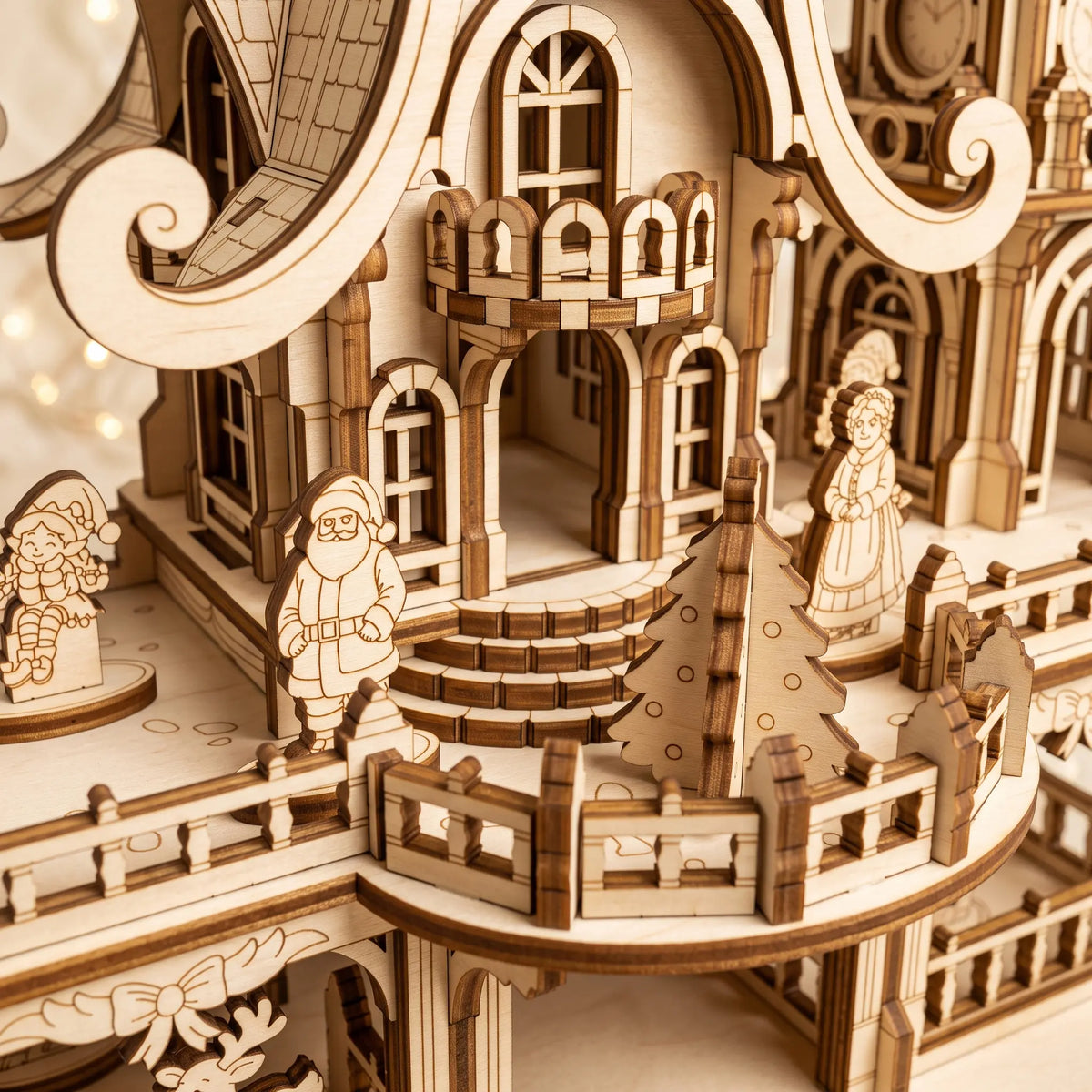 Macro of laser cut plywood Santa and Mrs Claus standing on curved balcony with mini evergreen tree.